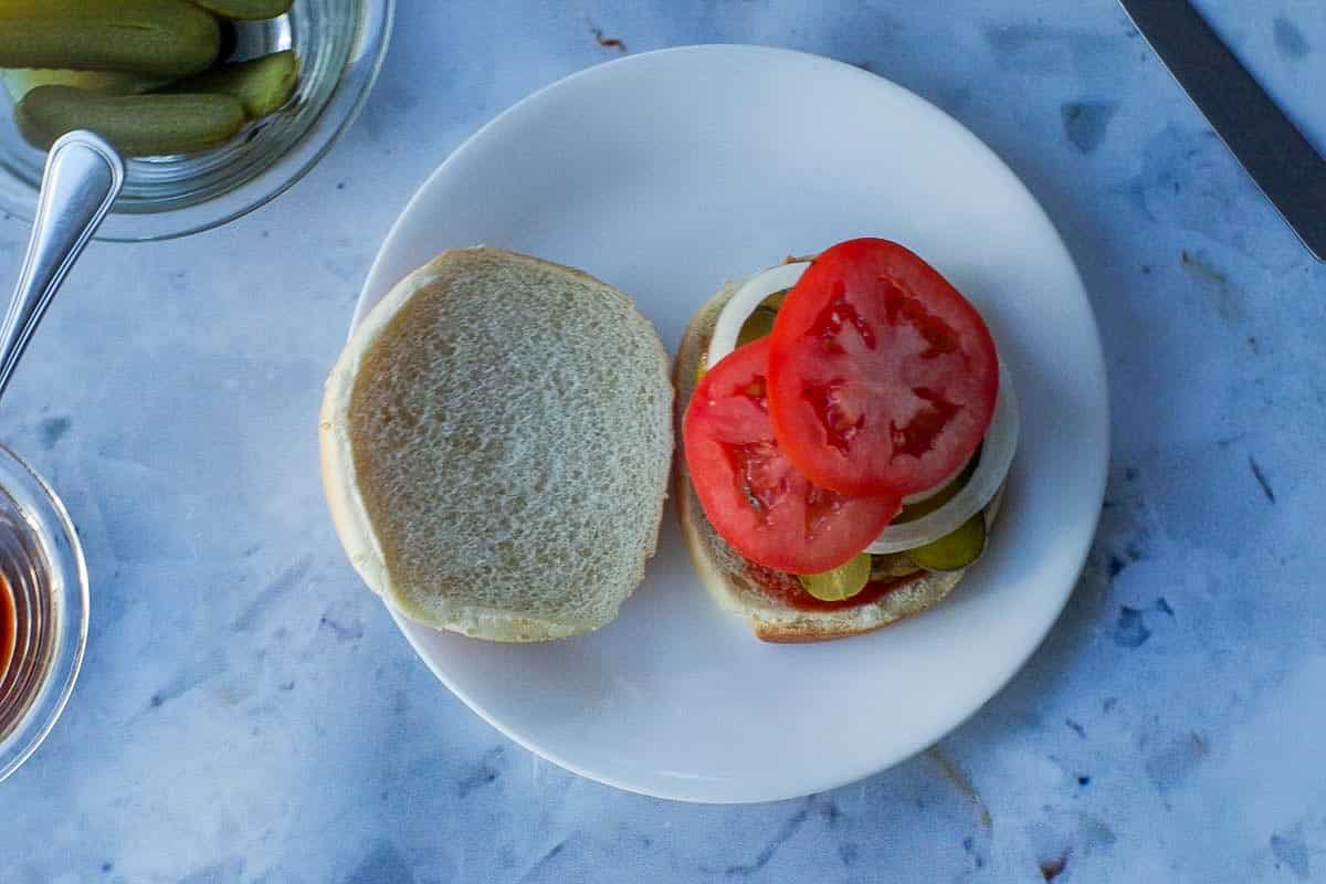 Pickles, onions and tomato added to the top of the burger.
