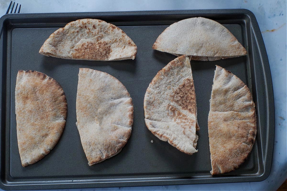 Pita halves on a baking sheet.