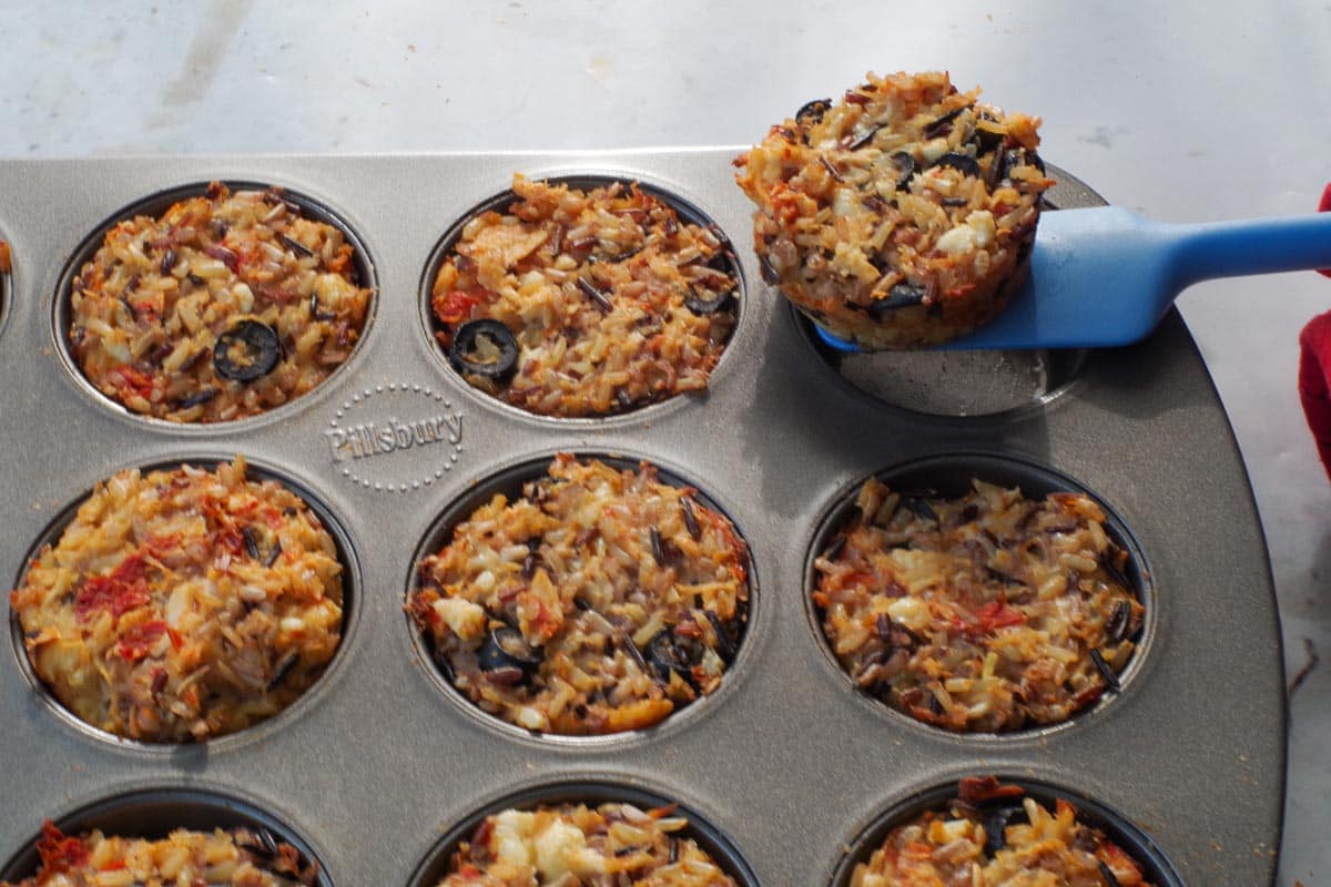Rice cup being gently removed with spatula.