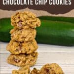 Zucchini chocolate chip cookies piled on top of each other with zucchini in background and cookies split in half in foreground