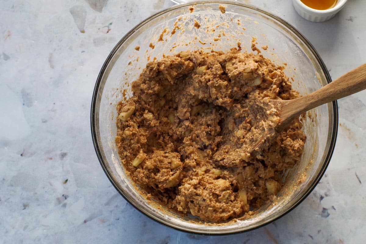 Wet ingredients mixed with dry ingredients in large glass bowl.