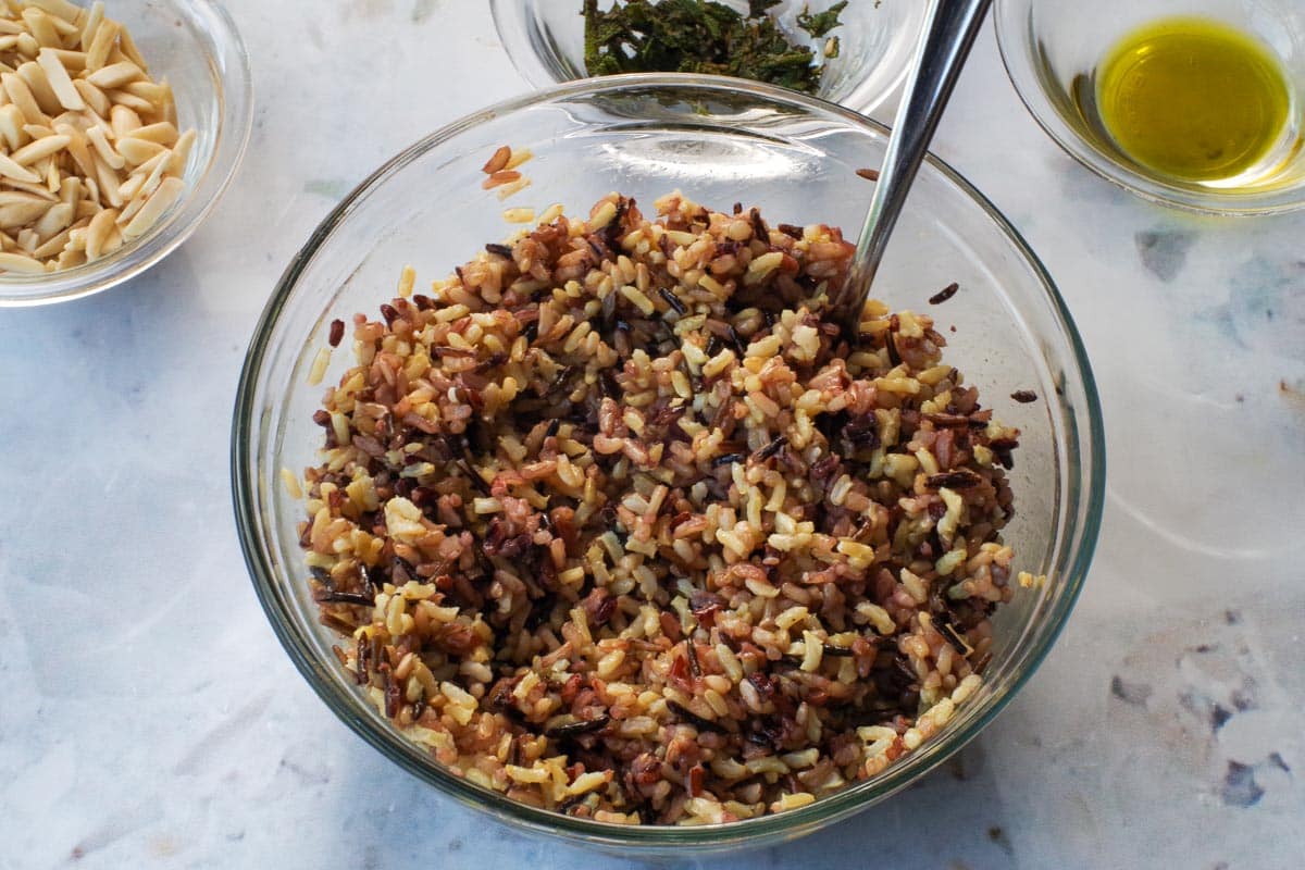 Cooked rice in a glass bowl with spoon.