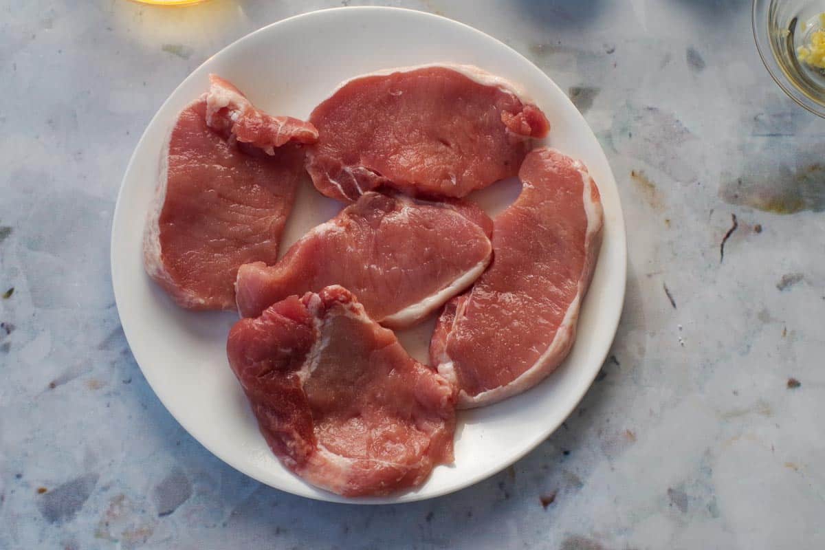 5 pieces of pork on a white plate. 