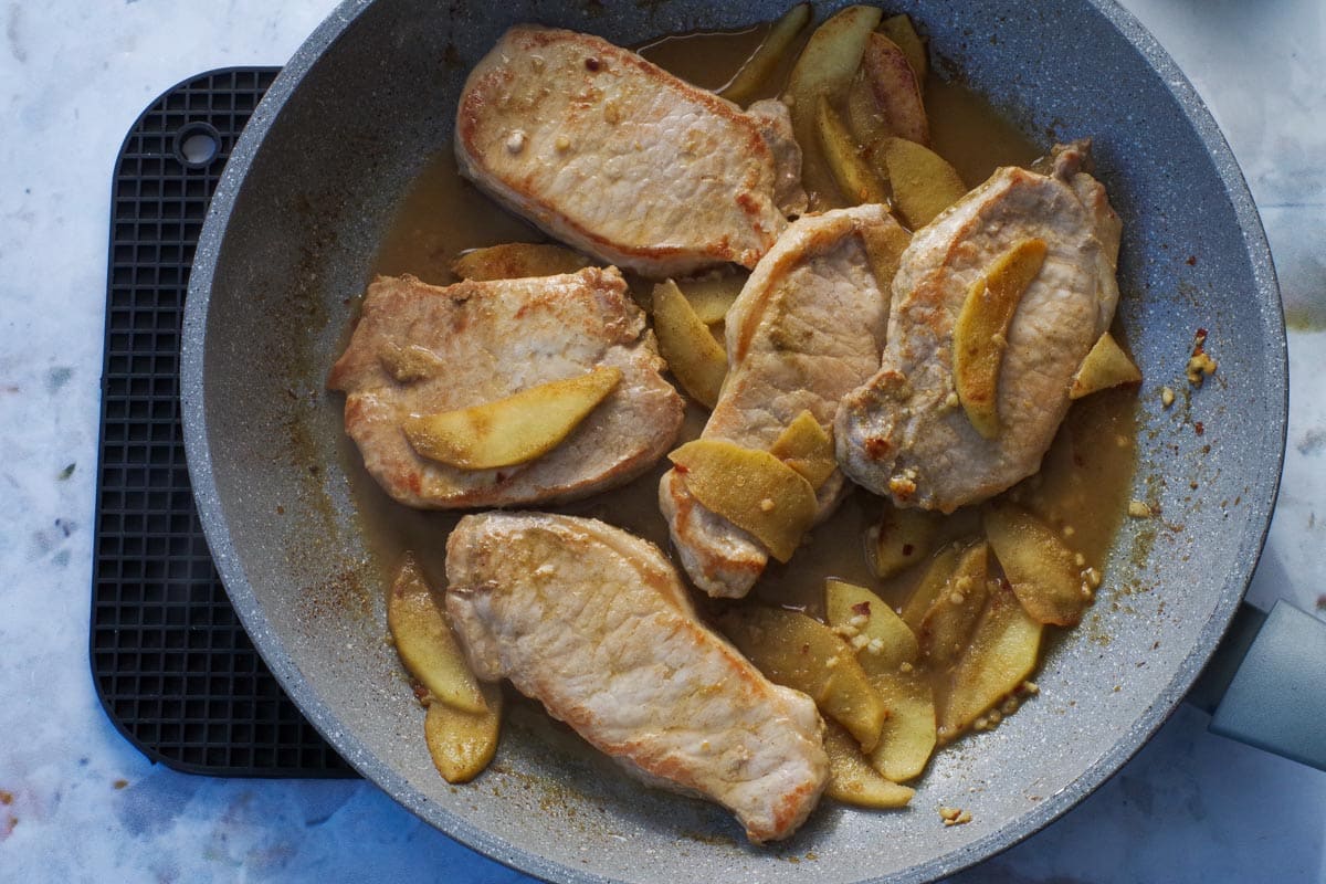 Apple pork cooked in a frying pan.