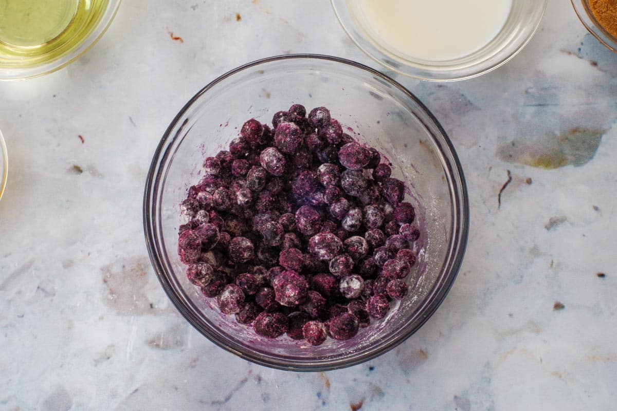 Frozen blueberries tossed in 1 tablespoon of flour in medium glass bowl.
