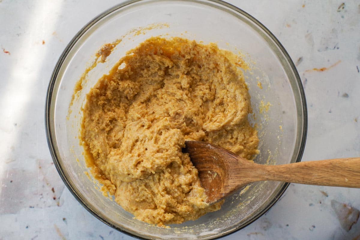 Dry and wet ingredients mixed together in large glass bowl.