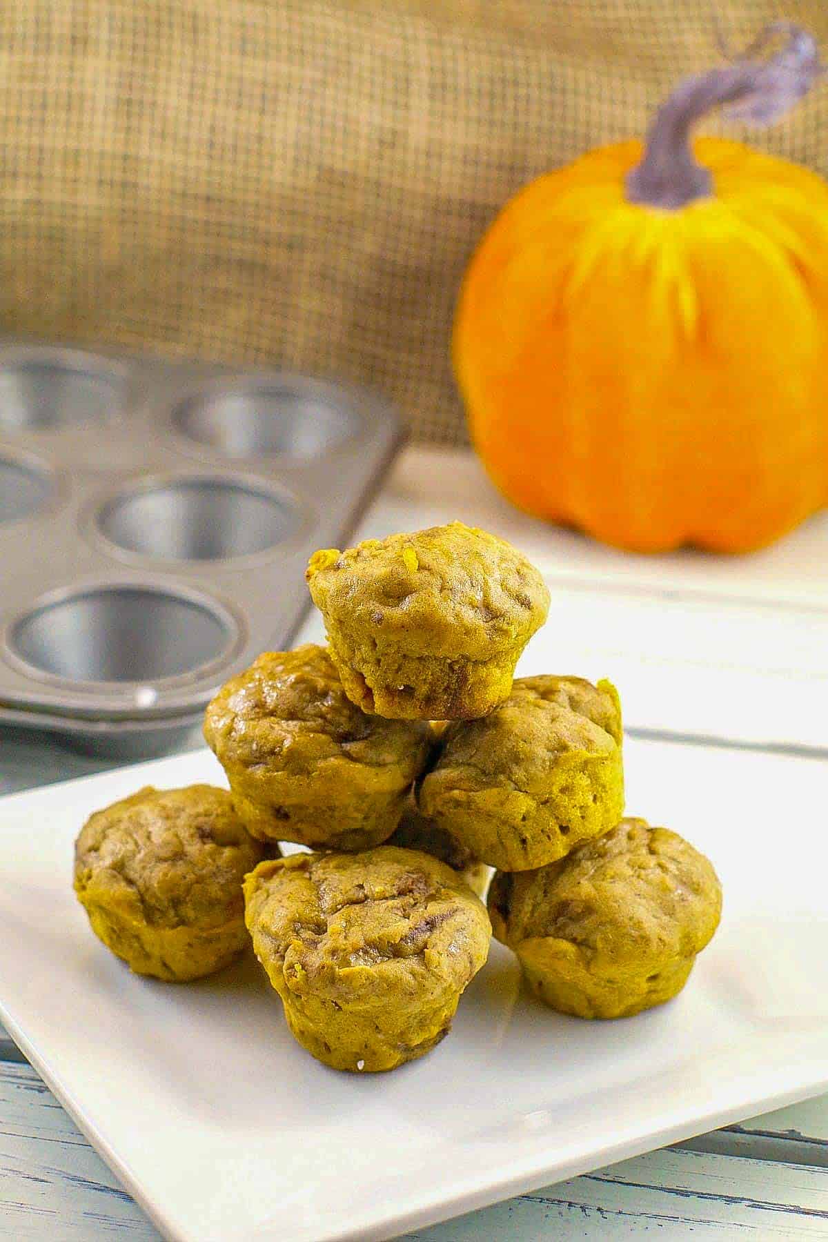 umpkin blondie bites stacked on a white plate with a plush pumpkin in the background