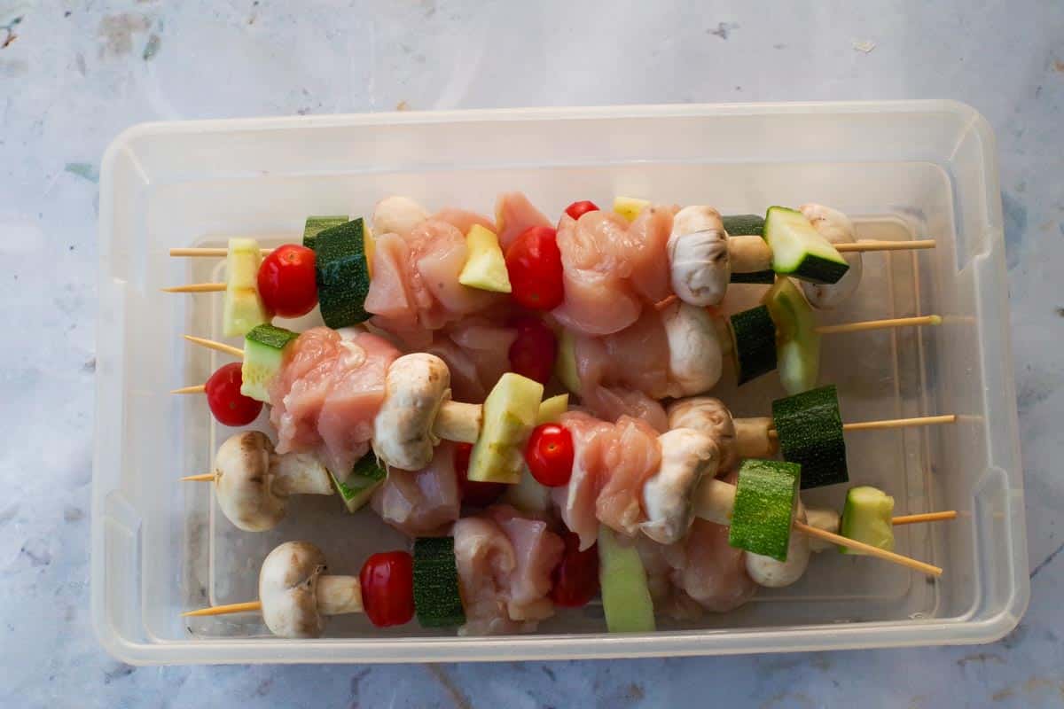 Kabobs in large container.