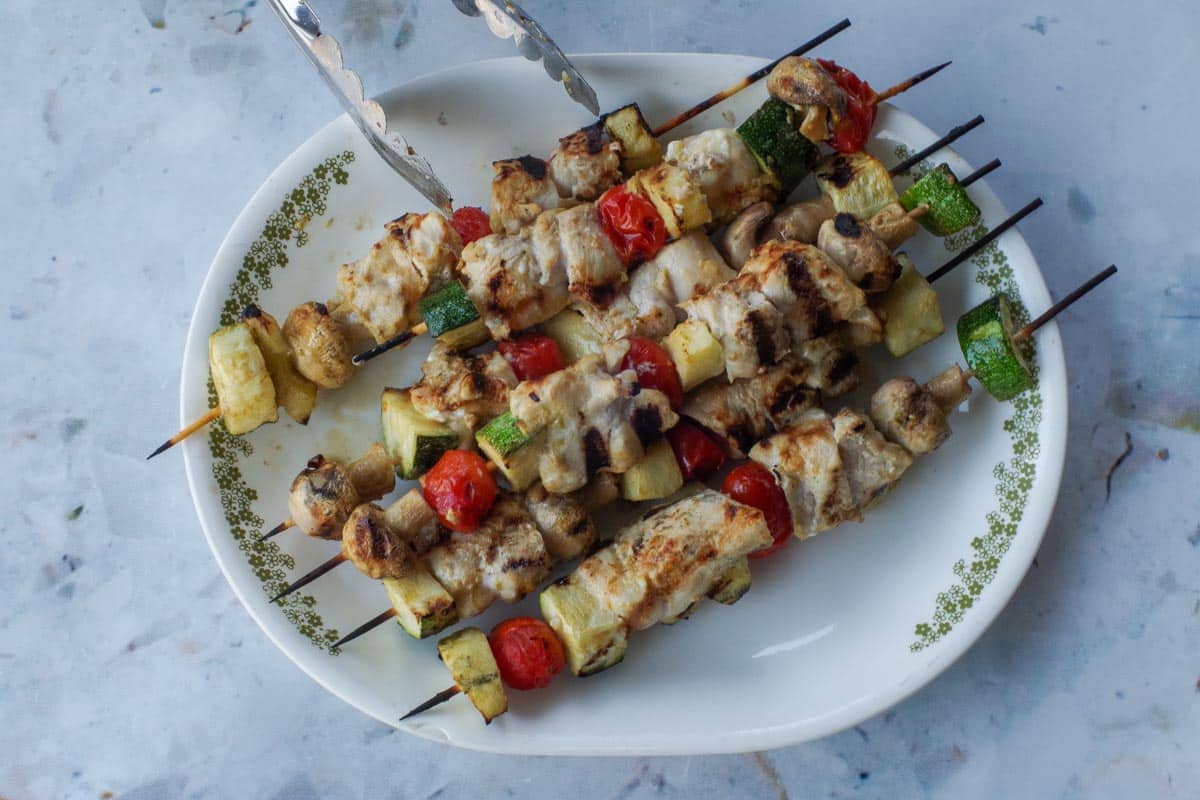 Cooked marinated grilled chicken kabobs on platter