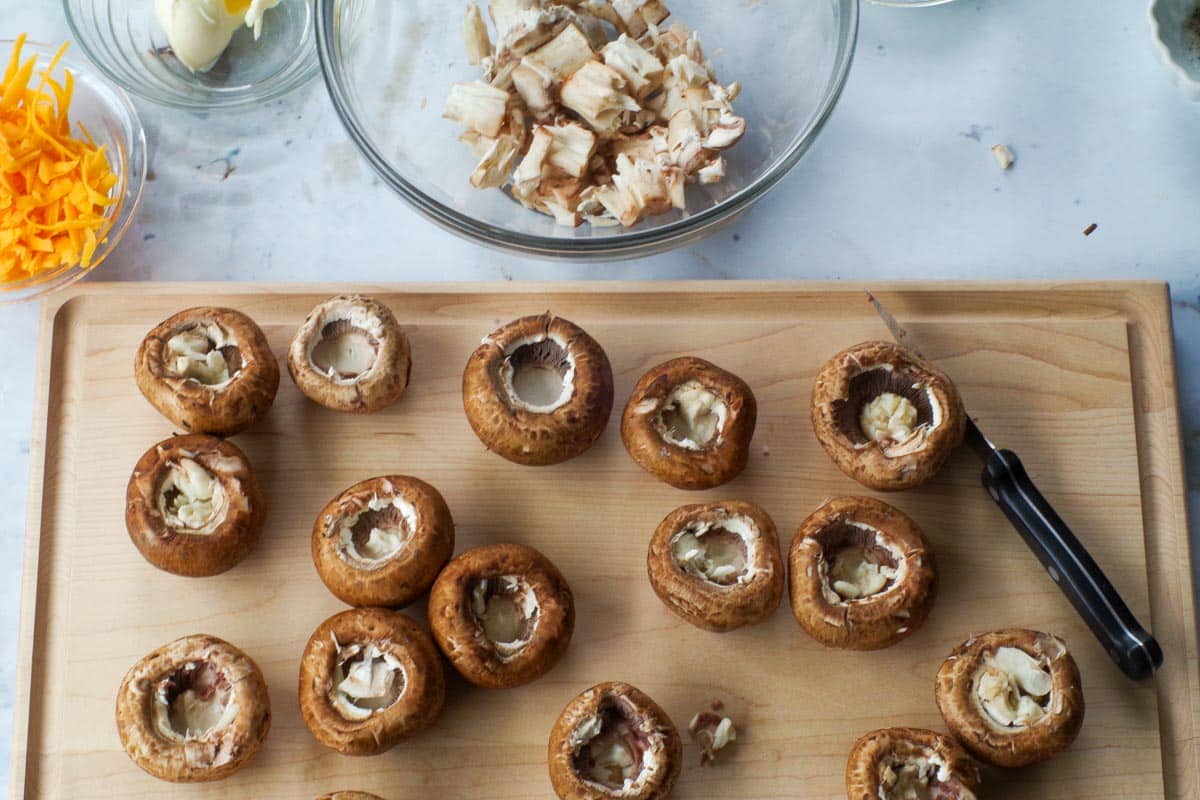 Mushrooms on cutting board with stems pulled out.