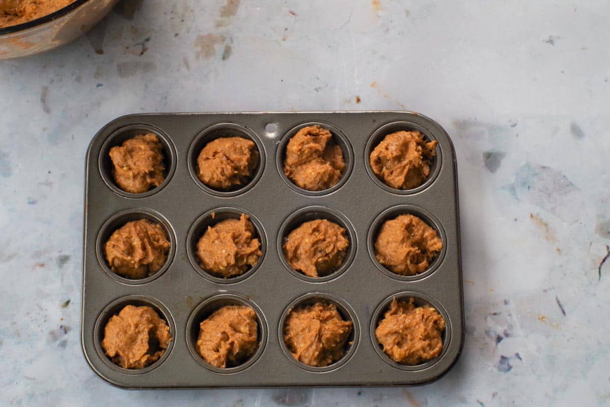 Pumpkin Blondie bites batter in mini muffin tin.