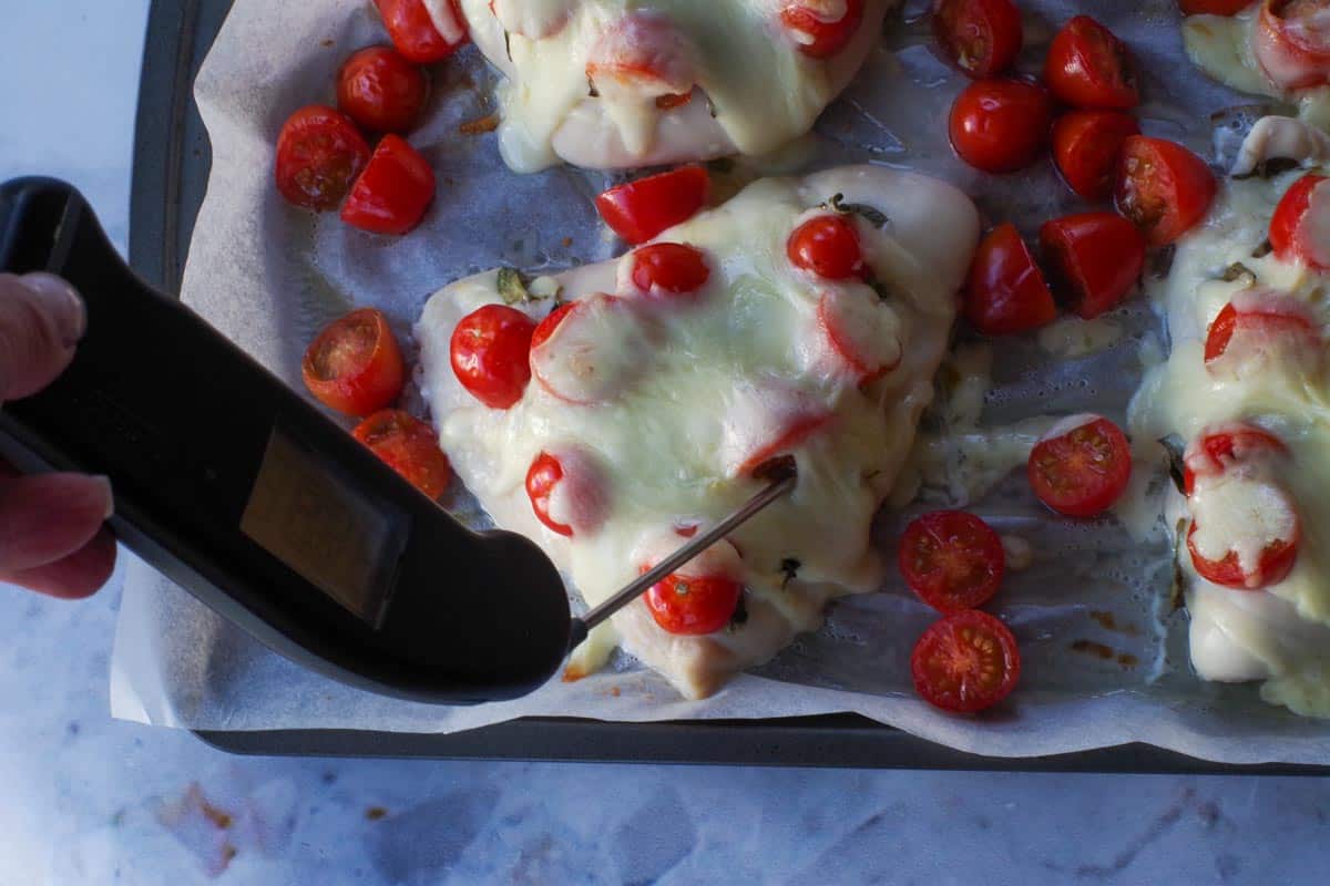 Chicken being tested with instant-read theremometer.