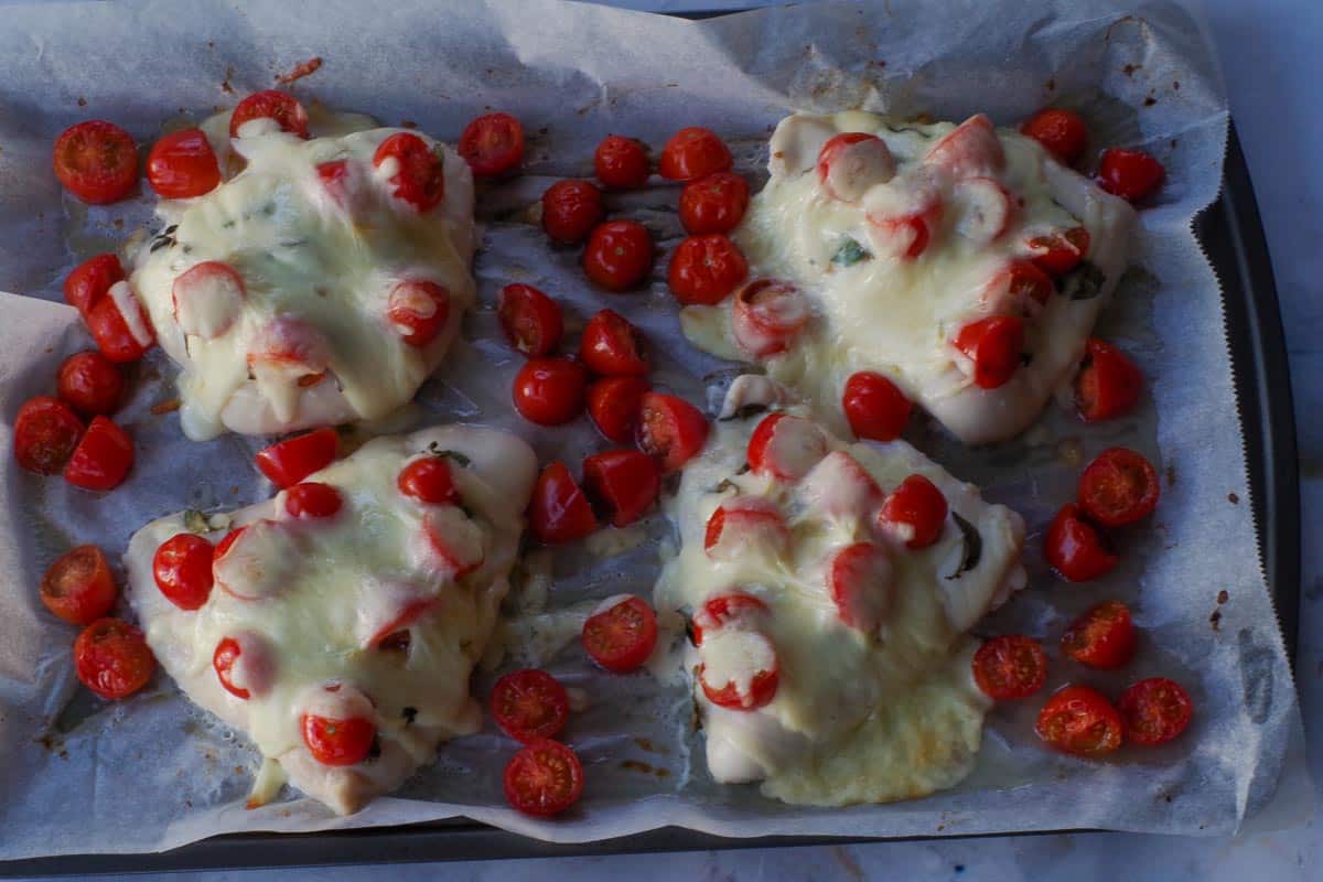 Cooked chicken breasts on a sheet pan.