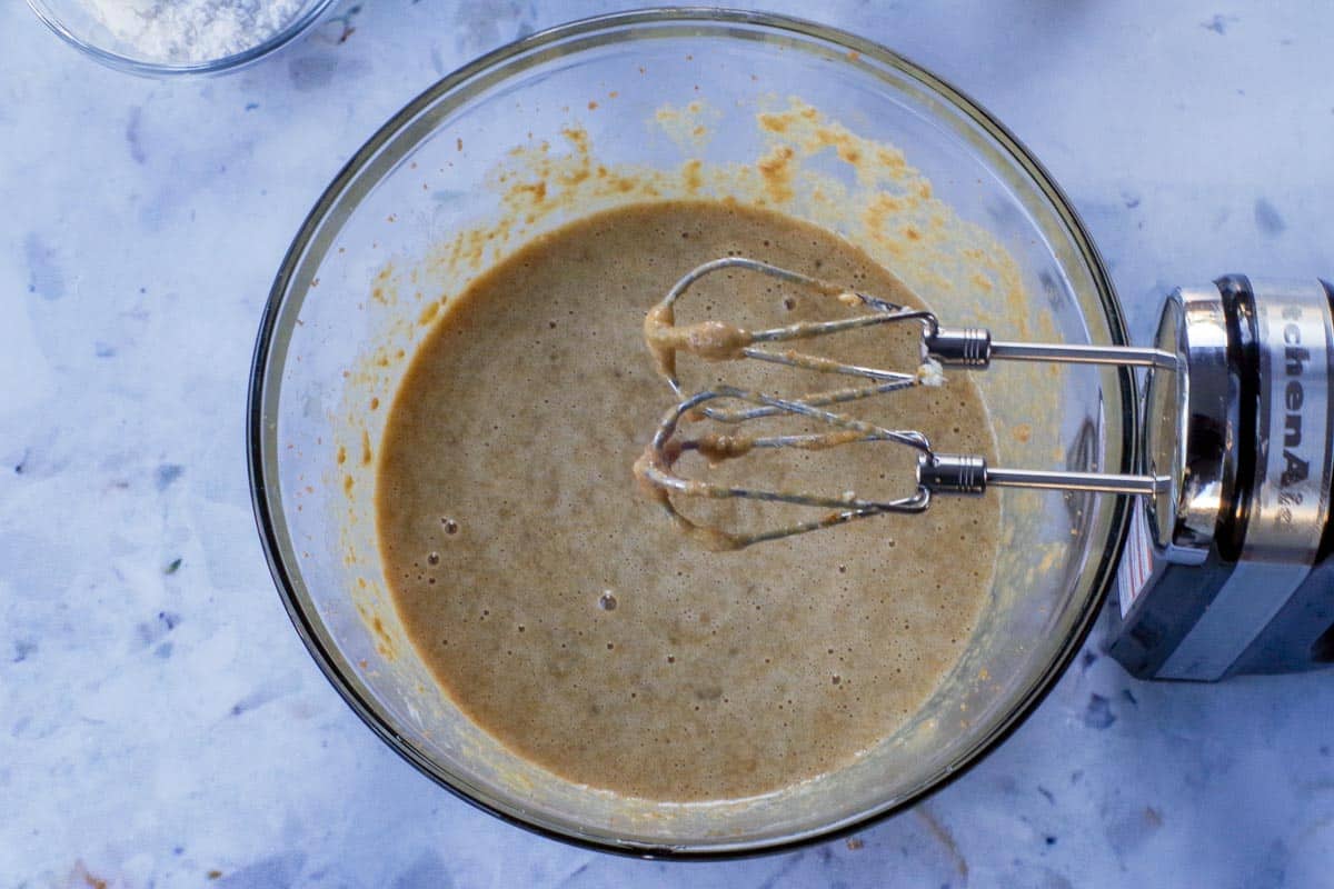 Wet ingredients added to butter/sugar mixture and beaten together in large glass bowl with beaters.
