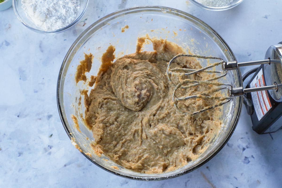 Dry ingredients beaten into wet mixture, in large glass bowl, with electric mixer.