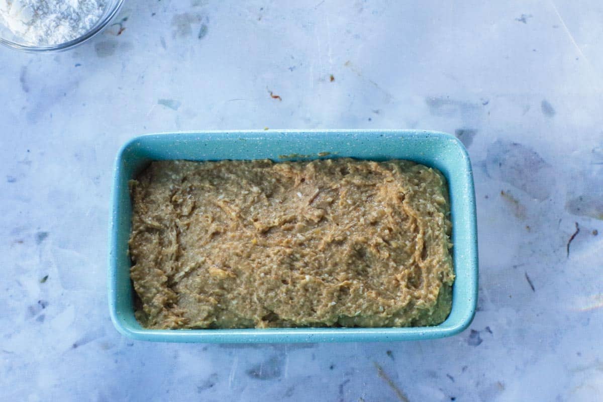 Tropical Banana Bread batter poured into a blue loaf pan.