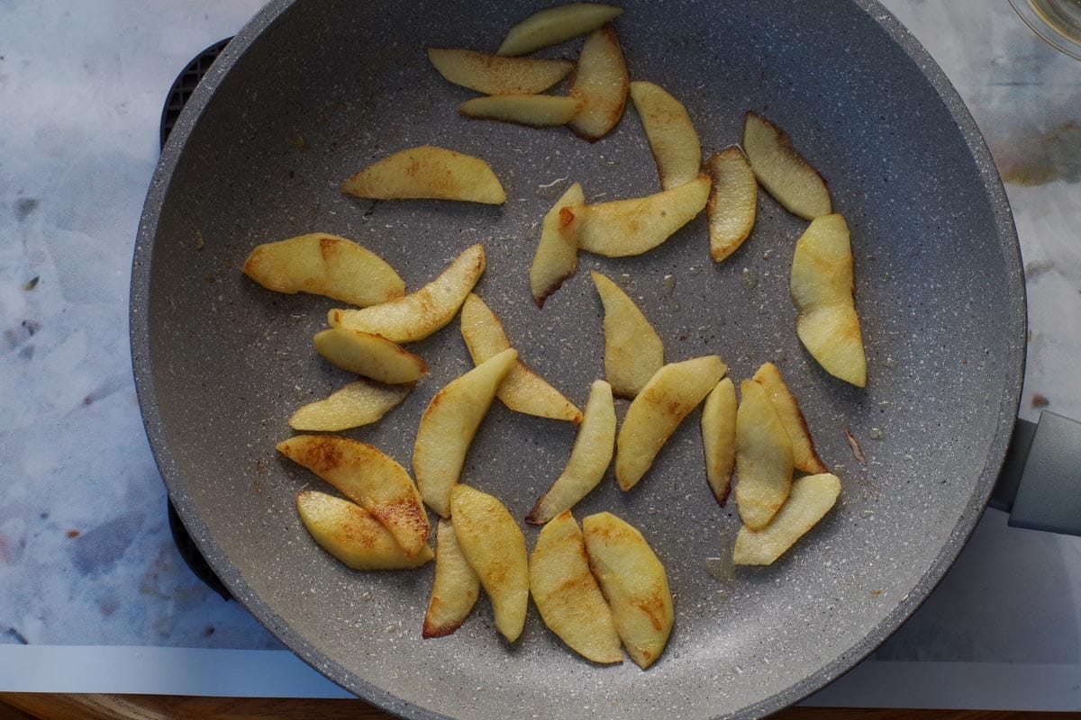 Cooked apples in butter in a frying pan