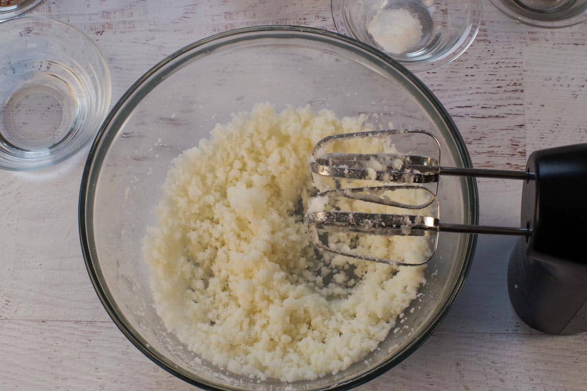 Sugar and shortening beat together in a large glass bowl.