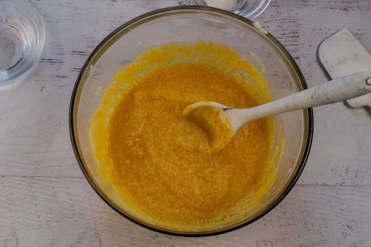 Pumpkin stirred into vegetable shortening mixture in large glass bowl.