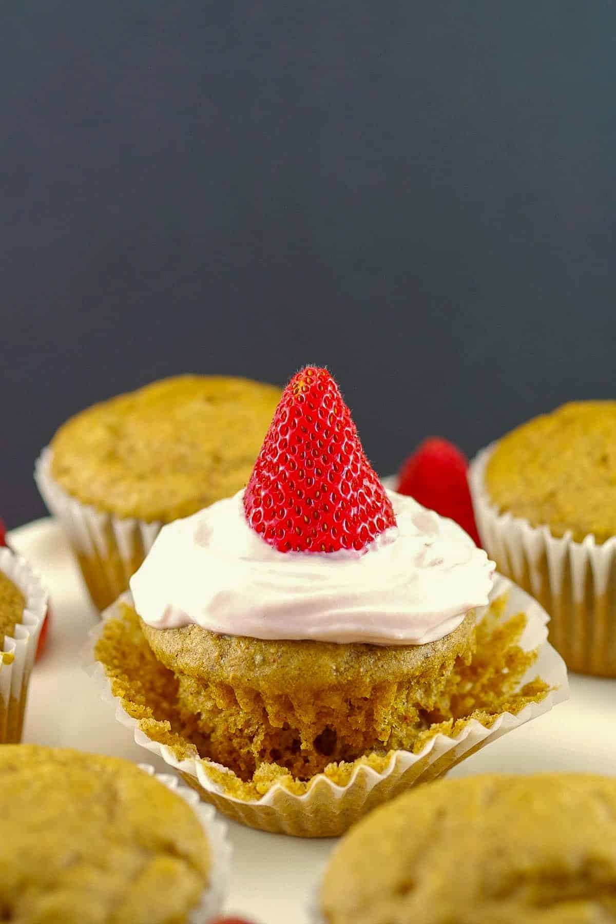 Strawberry Gingerbread Pancake Cupcakes with wrapper partly removed and more cupcake pancakes in the background.