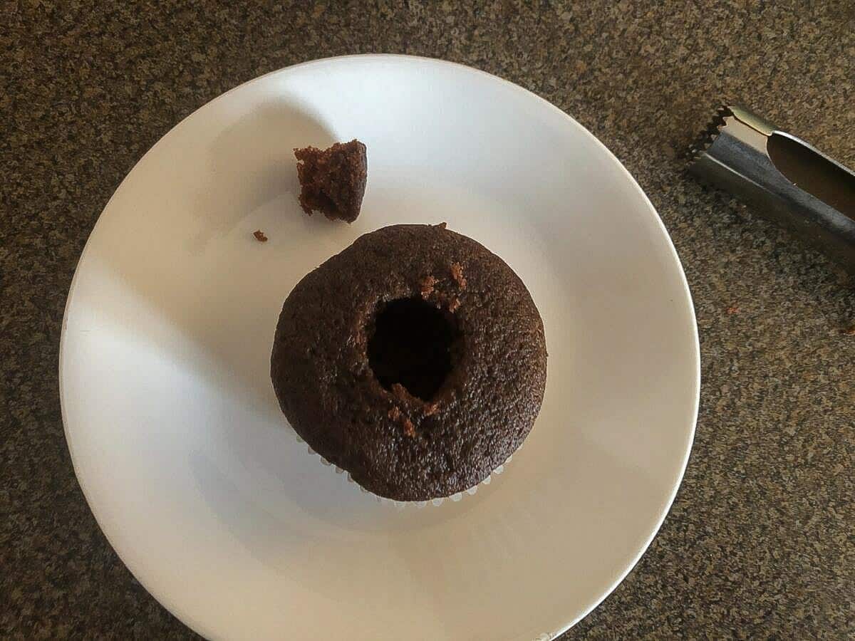 A cupcake with a hole in the middle from a apple corer.
