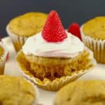 Pancake cupcake with Greek yogurt and strawberry topping, on loosened muffin liner wrapper, with other cupcake pancakes around it