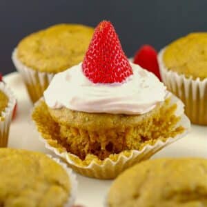 Pancake cupcake with Greek yogurt and strawberry topping, on loosened muffin liner wrapper, with other cupcake pancakes around it