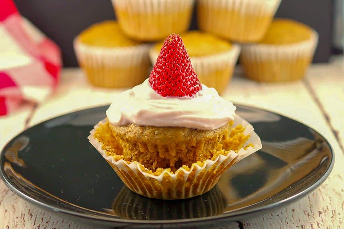 Gingerbread pancake cupcake on a black plate with more pancake cupcakes in the background.