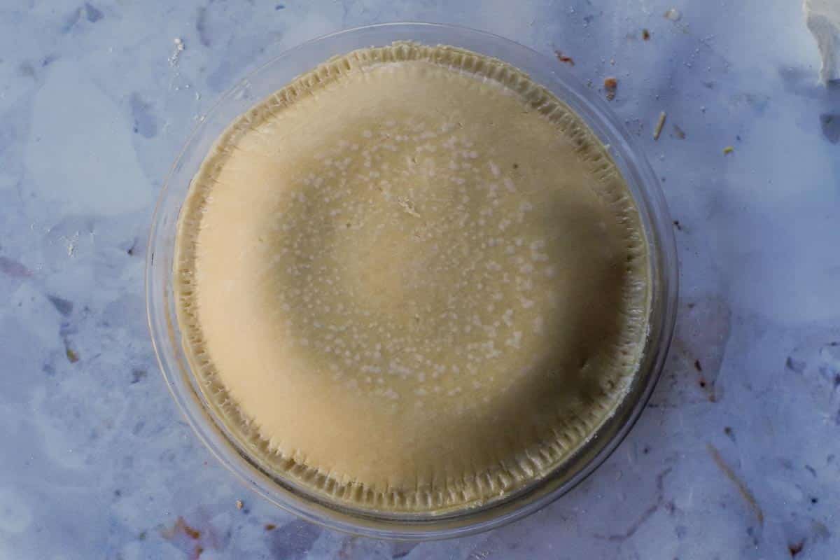 Top crust added and sealed with water and fork around the edges.