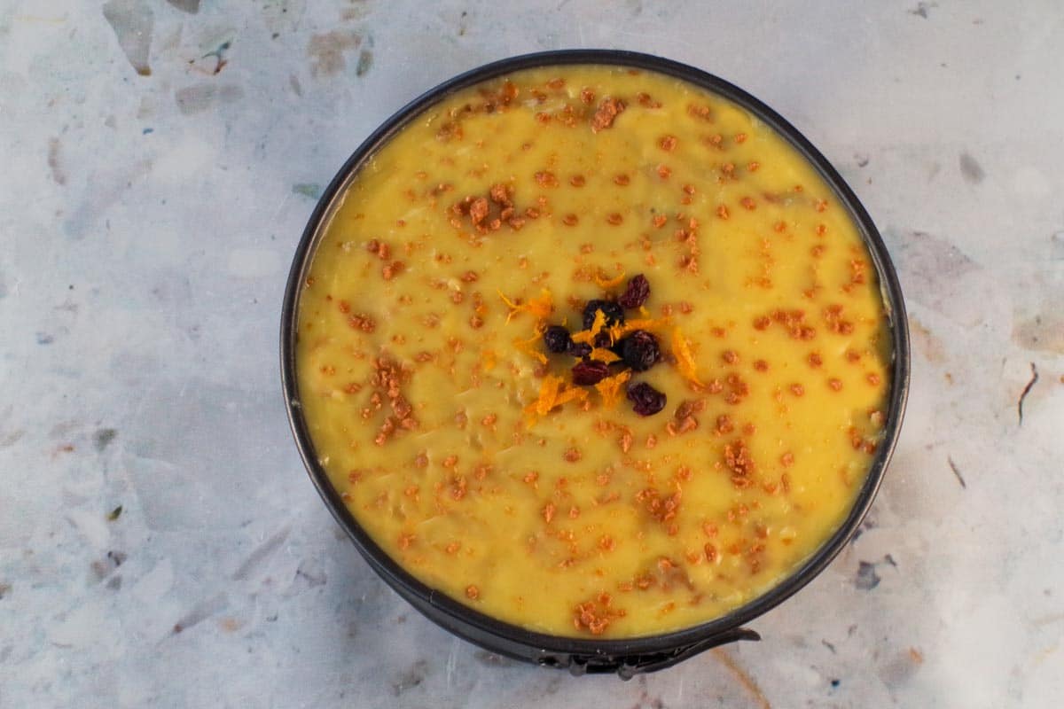 Bread pudding cheesecake with sauce and garnish.