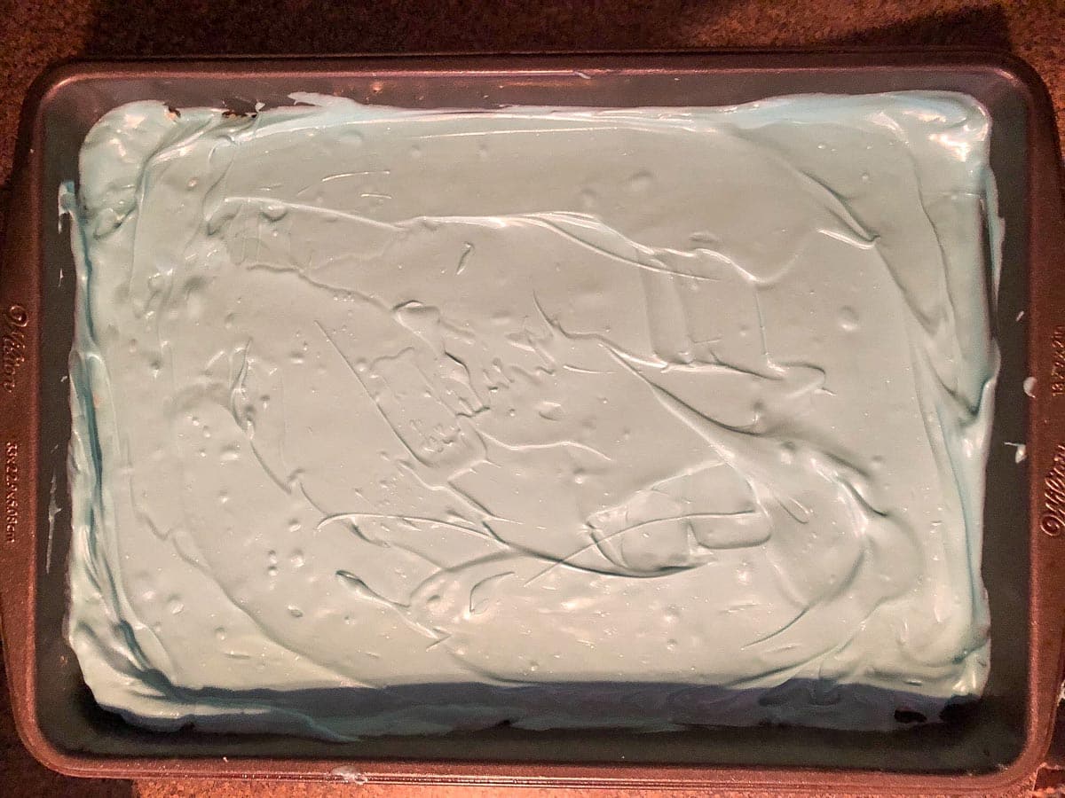 Light blue candy melts spread on rice krispie treats.