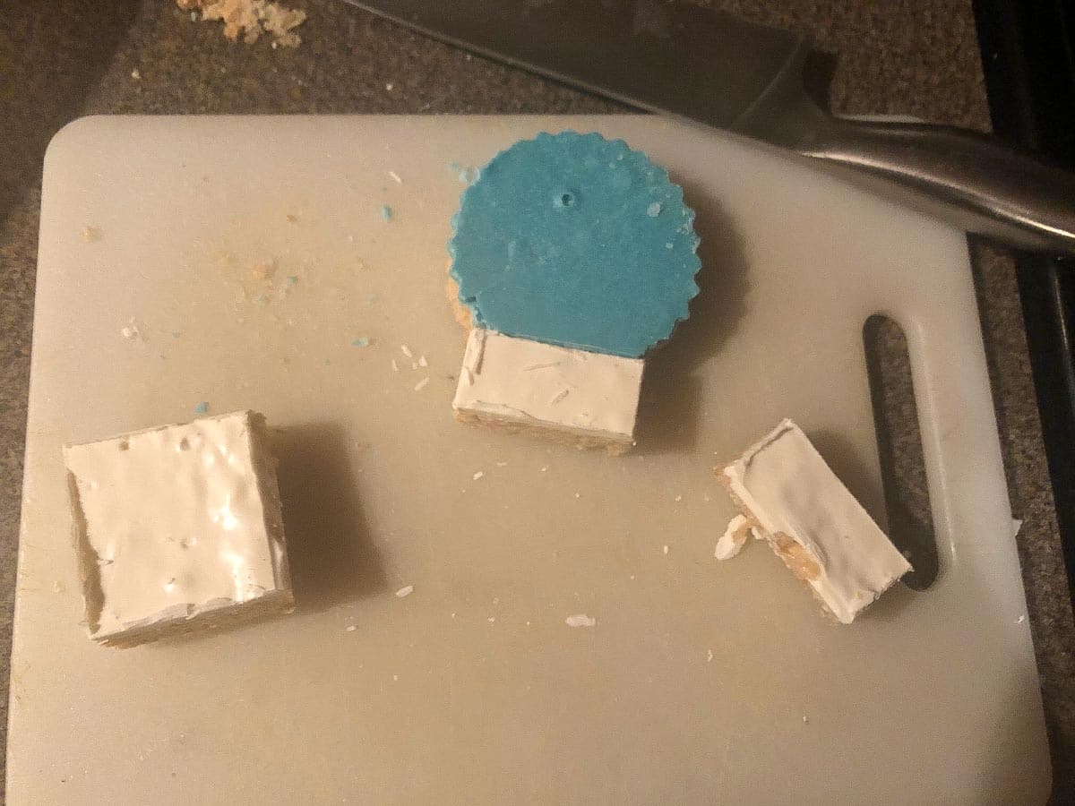 White rice krispie base being added to bottom of blue snow globe.