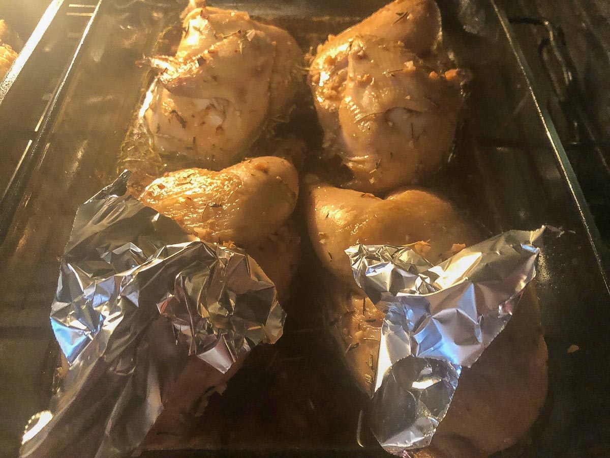 Hens placed in shallow roasting pan with legs covered with a little aluminum foil.