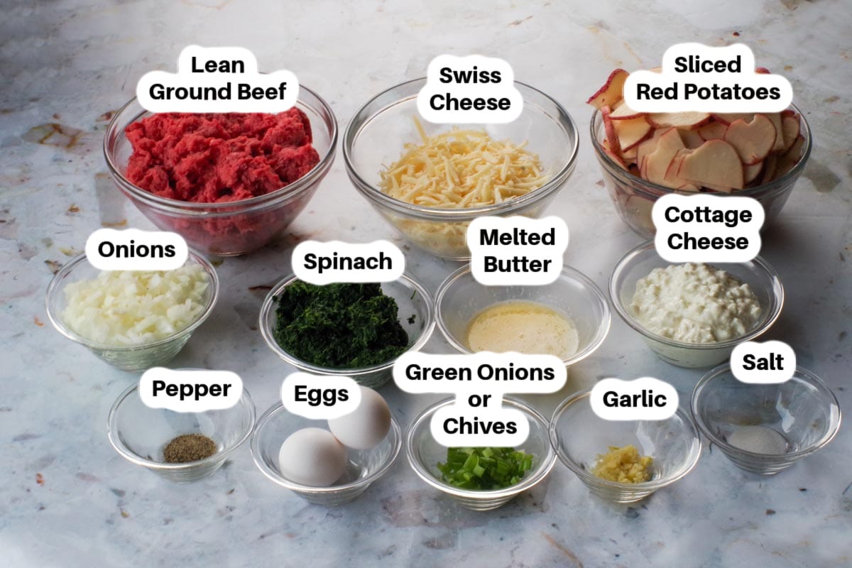 Ingredients in Ground Beef and Potato Casserole with Spinach in glass bowls, labelled.