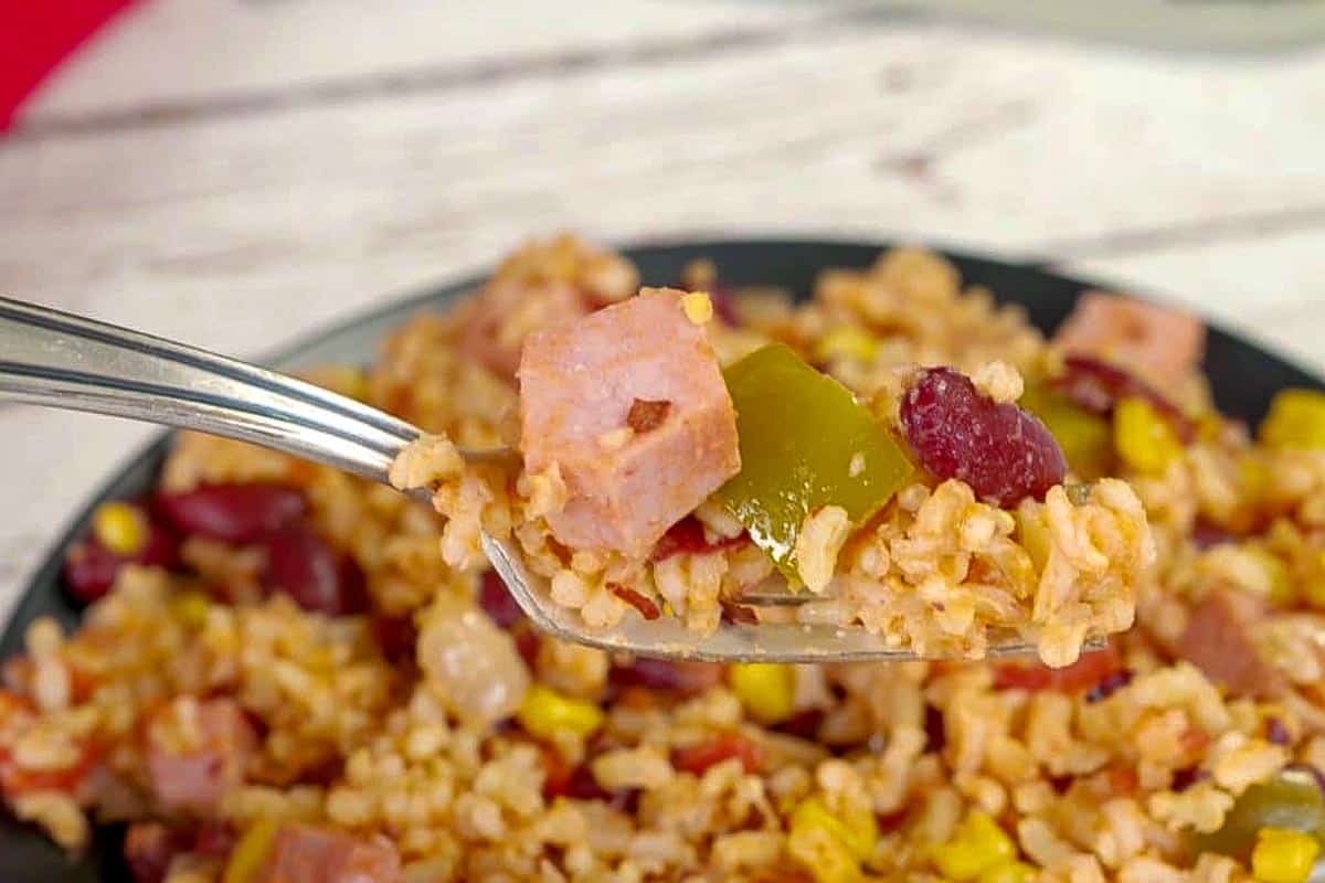 Leftover Ham, rice and beans being held up on a fork.
