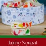 Jujube Nougat Candy in a Christmas container with 2 slices in front on a cutting board.