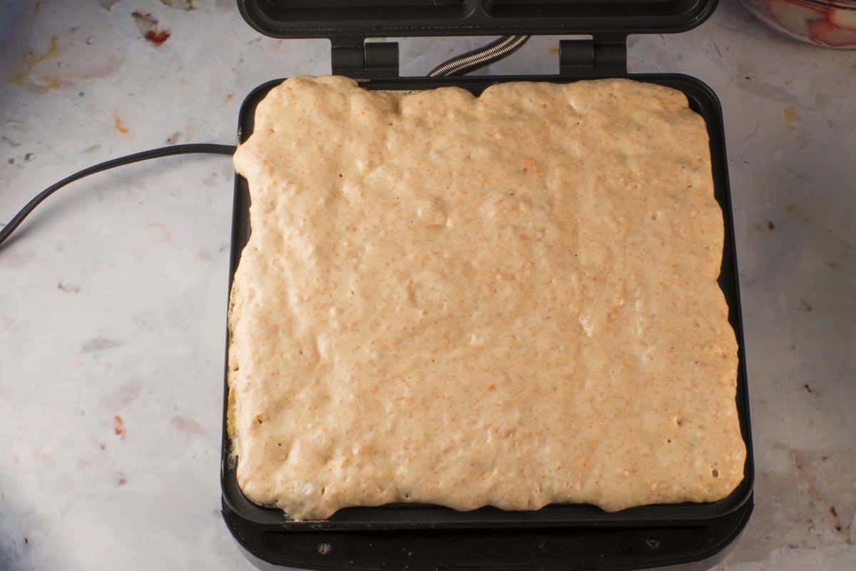 Waffle batter poured onto a hot waffle iron.