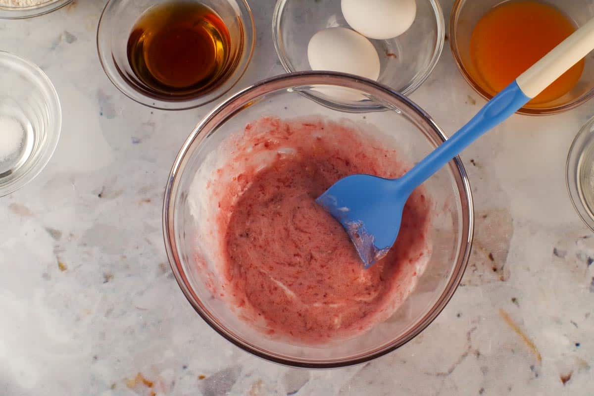 Strawberry sauce ingredients mixed together in a glass bowl.