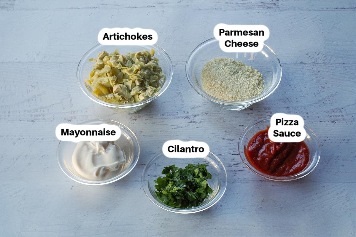 Ingredients in Hot Artichoke Pizza Dip in glass bowls, labelled.