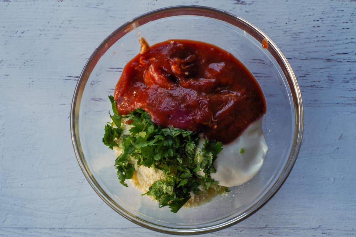 Al the Hot Artichoke Dip ingredients in a glass bowl.