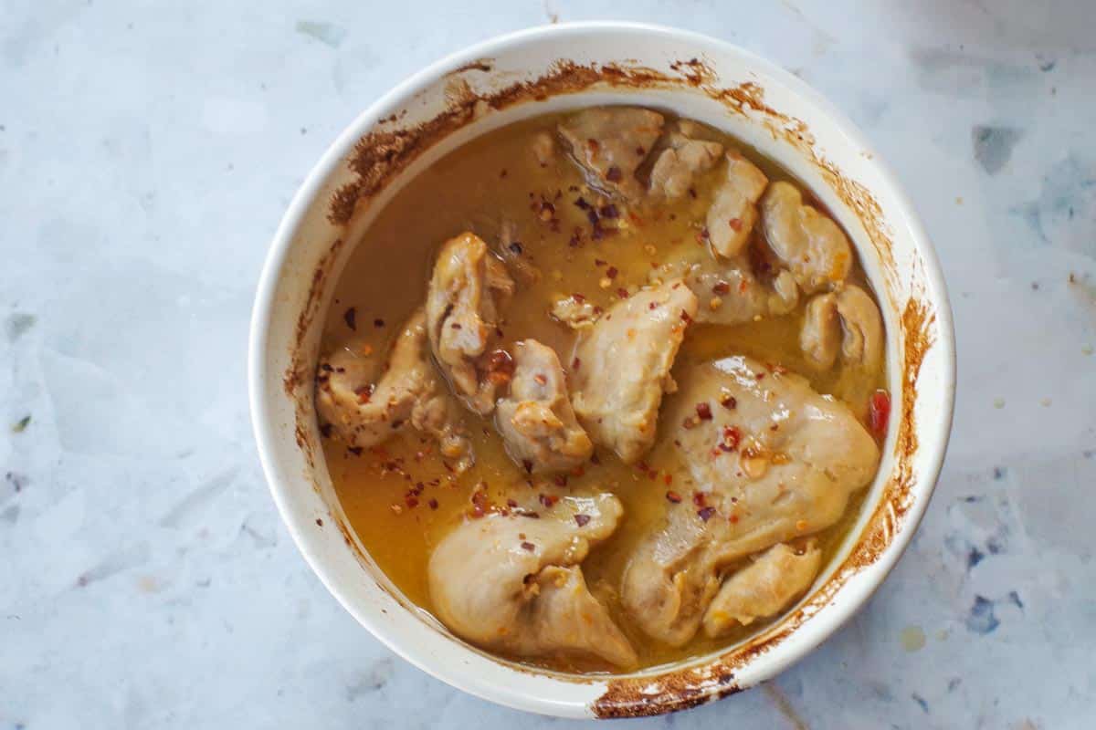 Apricot chicken with apricot jam cooked in a white casserole dish