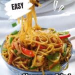 Singapore Fried Rice Noodles in a bowl with noodles being lifted out with chopsticks.