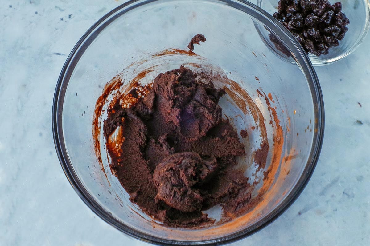 Almond butter, agave, vanilla and cocoa powder mixed together in a large glass bowl.