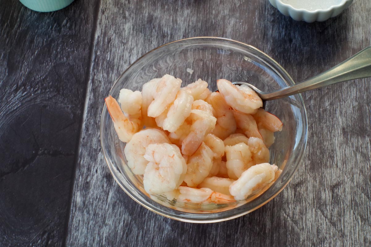 Shrimp in a small glass bowl with oil and fish sauce.