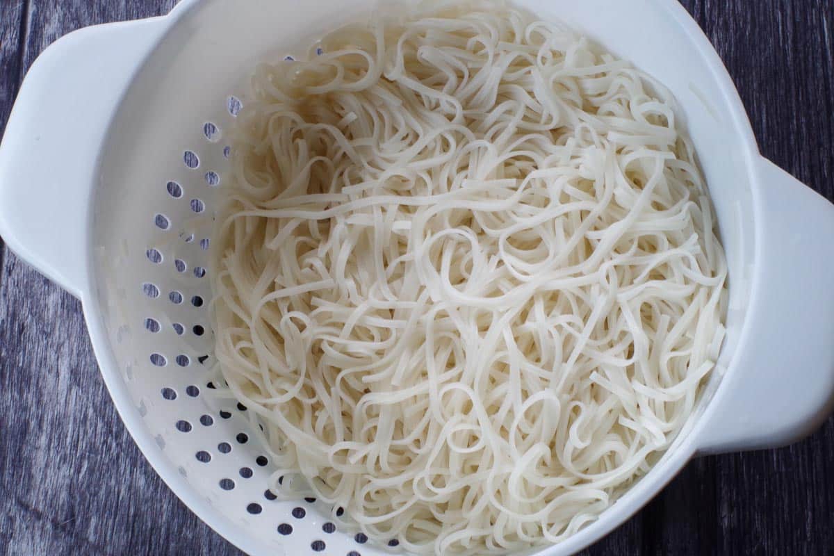 Rice moodles cooked, rinsed and drained in colander.
