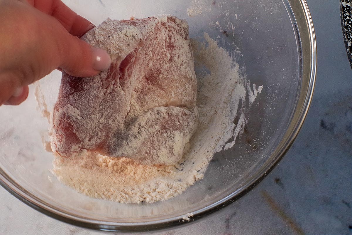 Pork being coated with flour.