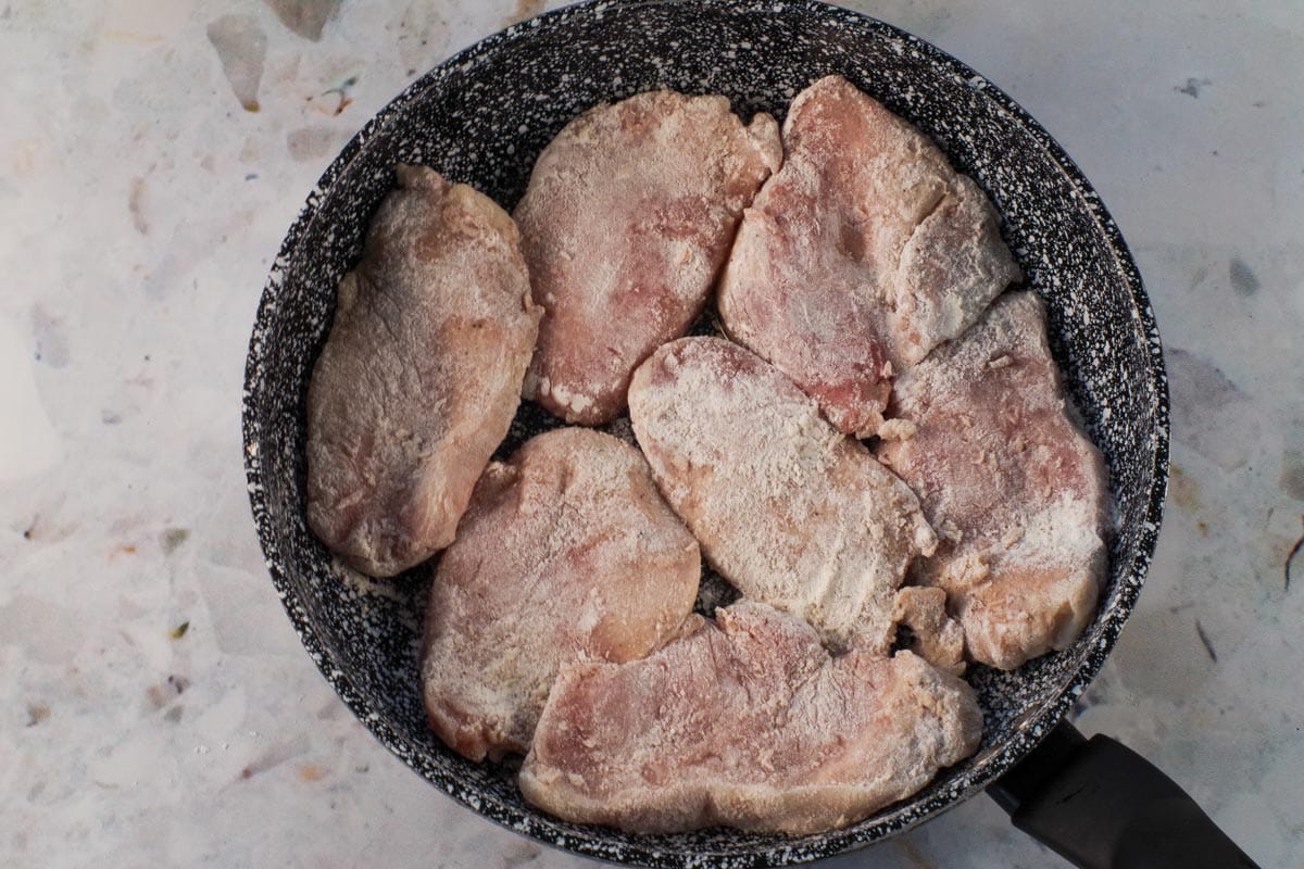Coated pork in frying pan with hot oil