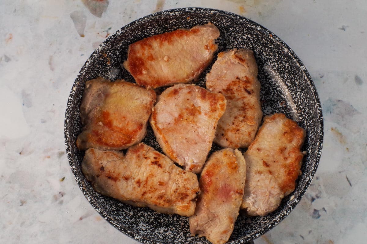 Pork cooked until lightly browned on both sides, in frying pan.