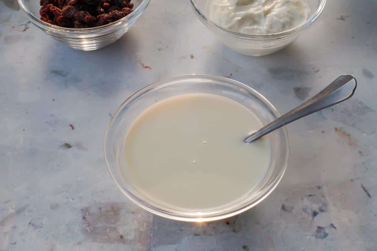 Milk mixed with vinegar in a small glass bowl.