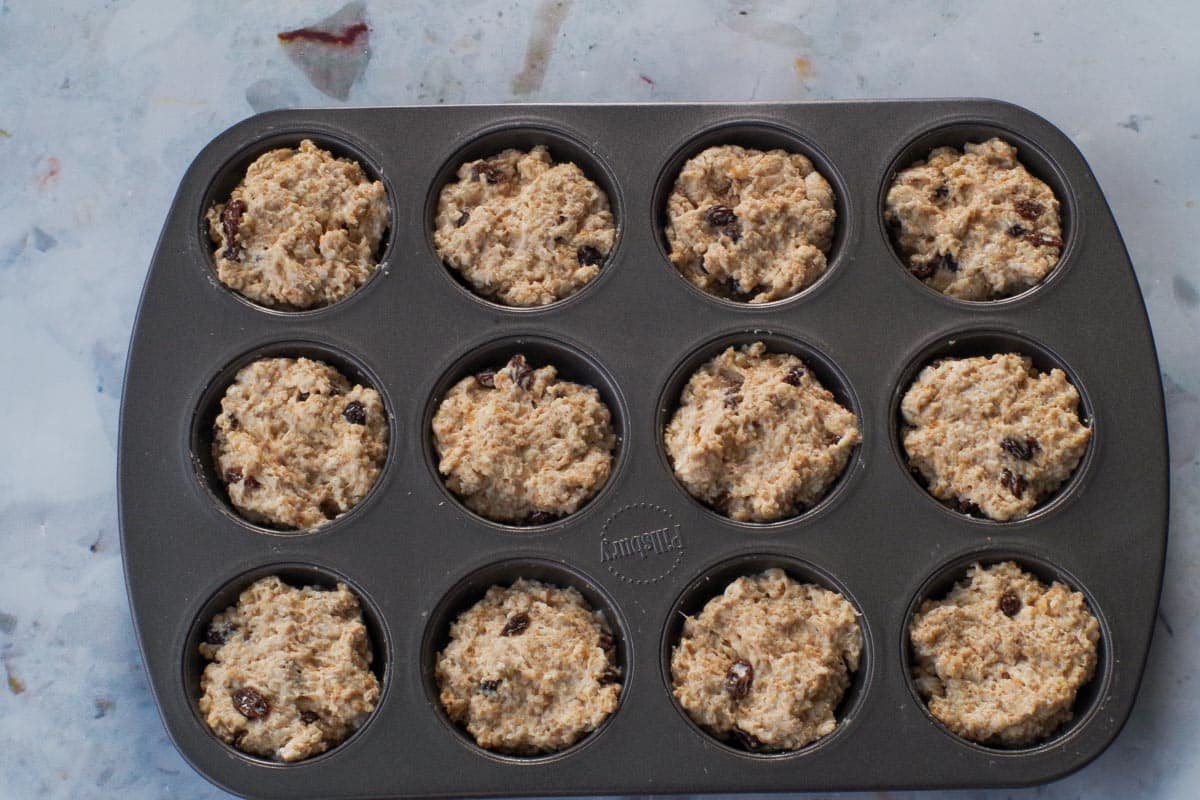 Dough spooned into a prepared muffin tin.